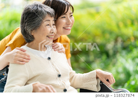 車椅子のシニア女性と介護する若い女性 118327874
