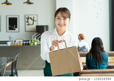商品を渡す若い女性のスタッフ 商品を渡す若い女性のスタッフ 118328394