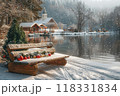 Sunny Winter Landscape with Snow-Covered Bench, Christmas Ornaments, and Snowy Trees in a Mountain Village 118331834