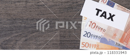 Inscription tax and euro banknotes. Time of calculating, return or tax payment. Copy space for text Inscription tax and euro banknotes. Time of calculating, return or tax payment. Copy space for text 118331943