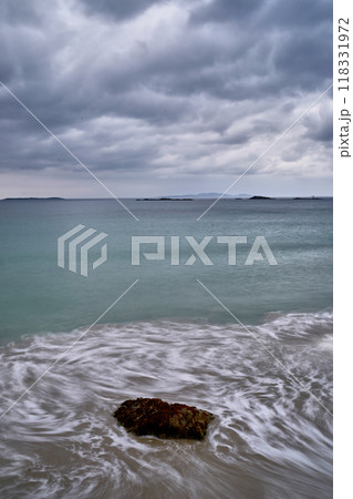 long exposure beach waves around rock cloudy day long exposure beach waves around rock cloudy day 118331972