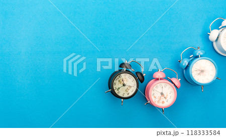 Flat lay retro beautiful new alarm clock on blue paper pastel color background Flat lay retro beautiful new alarm clock on blue paper pastel color background 118333584