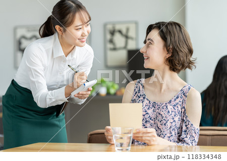 外国人観光客の接客をする若い女性の店員 118334348