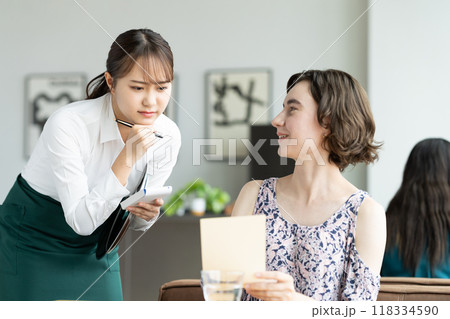 外国人観光客の接客で悩む若い女性の店員 118334590