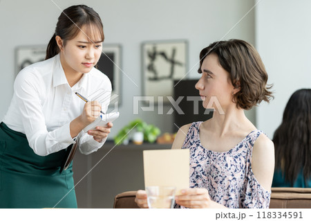 外国人観光客の接客で悩む若い女性の店員 外国人観光客の接客で悩む若い女性の店員 118334591