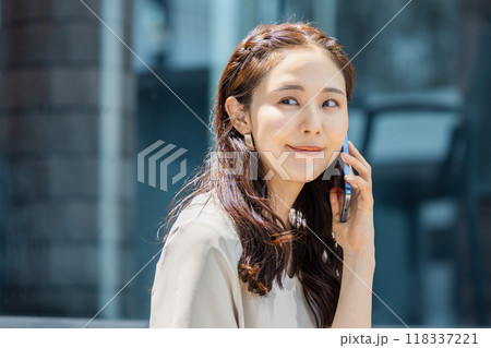 スマホで楽しそうにおしゃべりする女性 118337221