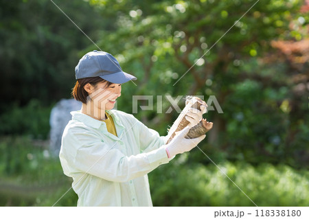 切った薪を見る女性　農作業 118338180