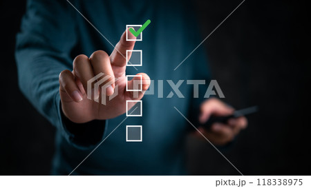 Hand touching checklist, green check mark highlighted. Concept of task completion, decision making, digital interface. Useful for business processes, project management. 118338975
