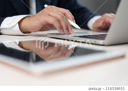 Businessman typing on a laptop with a stylus pen, representing professional office work. modern workspace and digital business activities. office productivity guides, and corporate presentations. 118339031