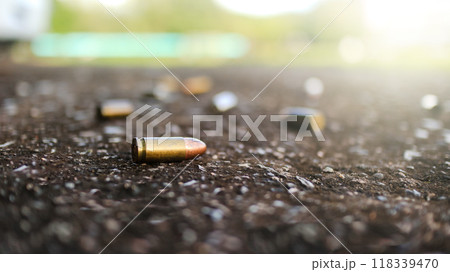 Spent bullet casing lying on dark ground with blur number 2 sign. Concepts of criminal investigations 118339470