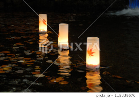 暖かな光で輝くランタンと落ち葉 118339670