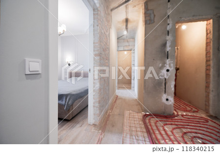 Photo collage of hallway and bedroom before and after refurbishment. Old apartment with underfloor heating pipes and new renovated flat with bed, doorway, elegant interior design. Focus on the switch. 118340215