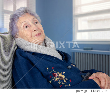 Senior Alzheimer's patient seated in a chair, indifferent and passive, illustrating the deep cognitive and motor decline caused by severe senile dementia and personality degradation. 118341206