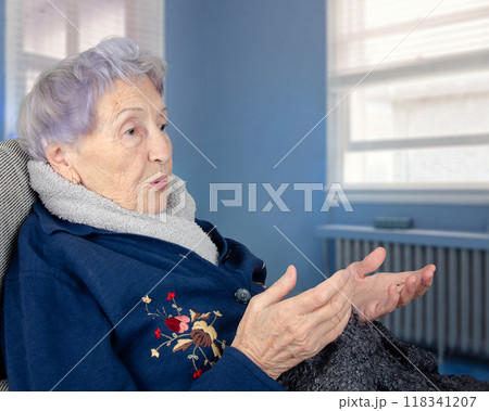 Elderly Alzheimer's patient in a nursing home setting, gesturing while talking to herself, highlighting the effects of senile dementia on communication and cognitive decline. Elderly Alzheimer's patient in a nursing home setting, gesturing while talking to herself, highlighting the effects of senile dementia on communication and cognitive decline. 118341207