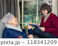 Elderly care in action: Social worker listens intently, taking notes as senior resident speaks passionately about her experiences. 118341209