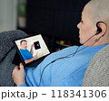 Post-chemo patient consults remotely with surgeon, who uses X-rays to explain upcoming procedure, demonstrating accessible care. 118341306