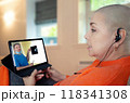 Cancer survivor participates in virtual medical discussion, attentively listening to doctor's explanation of X-ray findings on tablet. 118341308