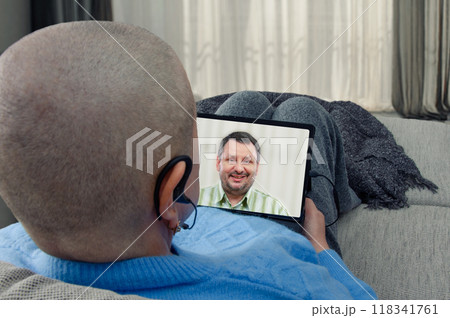 Remote therapy session: cancer patient connects with psychologist via tablet, illustrating the importance of mental health in treatment. Remote therapy session: cancer patient connects with psychologist via tablet, illustrating the importance of mental health in treatment. 118341761
