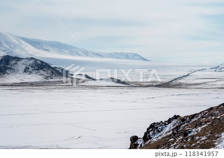 The road is far away through the snow-capped hills. Mongolia. 118341957