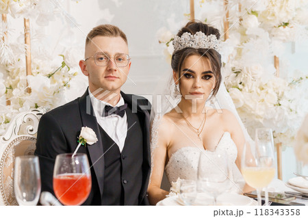 Elegant Wedding Celebration: Bride and Groom Surrounded by Floral Splendor 118343358