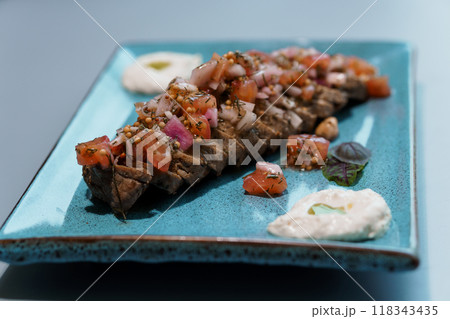 Exquisite Plated Gourmet Bruschetta with Tomato and Onion Topping on Modern Blue Ceramic Dish 118343435