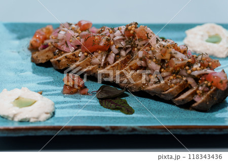Gourmet Presentation of Sliced Grilled Steak with Fresh Salsa on Elegant Blue Plate Gourmet Presentation of Sliced Grilled Steak with Fresh Salsa on Elegant Blue Plate 118343436
