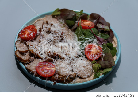 Fresh Italian Porchetta Salad with Tomato and Grated Cheese on a Sky Blue Ceramic Plate Fresh Italian Porchetta Salad with Tomato and Grated Cheese on a Sky Blue Ceramic Plate 118343458