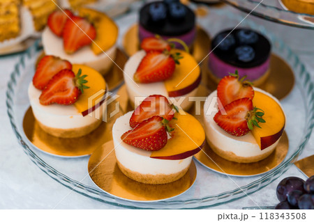 Elegant Assortment of Fruit-Topped Mini Desserts on Glass Platter Elegant Assortment of Fruit-Topped Mini Desserts on Glass Platter 118343508