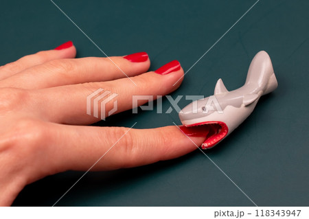Shark bites a woman's hand with red nails, shark attack on human 118343947
