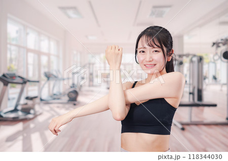 ジムでストレッチをする若い女性 ジムでストレッチをする若い女性 118344030