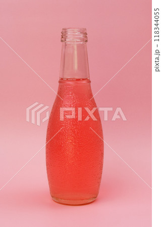 Transparent glass bottle with colorful liquid, unusual background 118344055