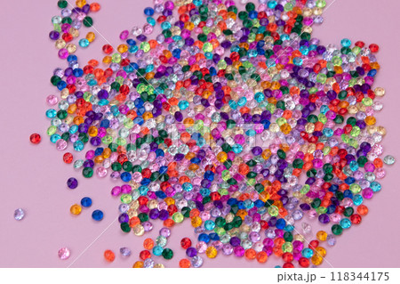 Multicolored tiny faceted crystals on a pink background, beautiful colorful texture 118344175