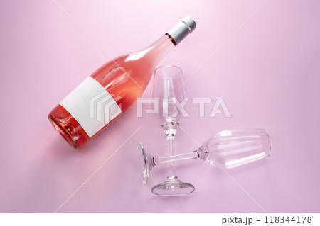 Wine bottle mockup, unopened bottle of rose wine and two glasses on pink background, top view, copy space, flat lay 118344178