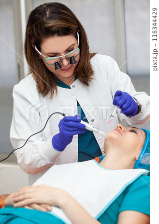 Application of an anti-aging facial rejuvenation cocktail using micro needles. Dermatology concept. Aesthetic medicine concept. Application of an anti-aging facial rejuvenation cocktail using micro needles. Dermatology concept. Aesthetic medicine concept. 118344429
