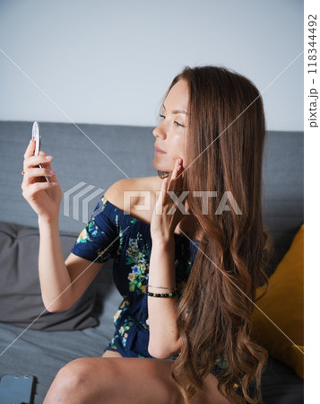 The girl looks into a small mirror 118344492