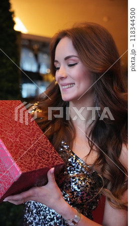 Girl holding a box with a gift red color 118344500