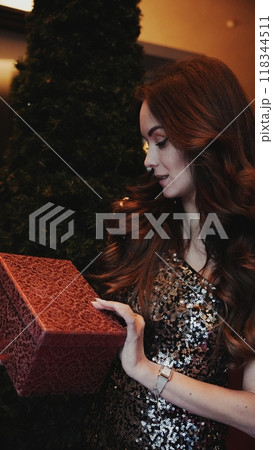 Girl holding a box with a gift red color 118344511