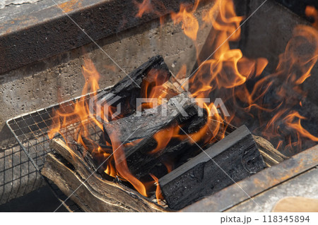 バーベキューで炭をおこす 118345894