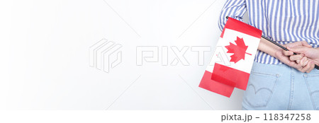 Miniature Canadian flag stands out of the back pocket of blue jeans. 118347258