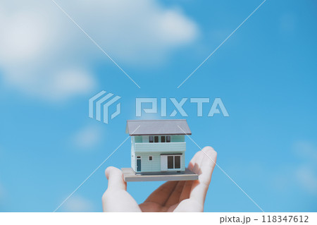 住宅模型を持つ人の手と青空背景 118347612