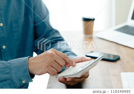 電卓で計算する男性の手元 118349495