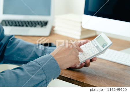 電卓で計算する男性の手元 118349499