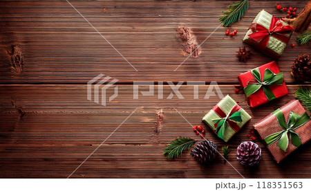 木目背景に映えるクリスマスギフトと松ぼっくりの装飾：背景素材 118351563