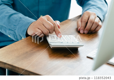 電卓で計算する男性の手元 電卓で計算する男性の手元 118352043