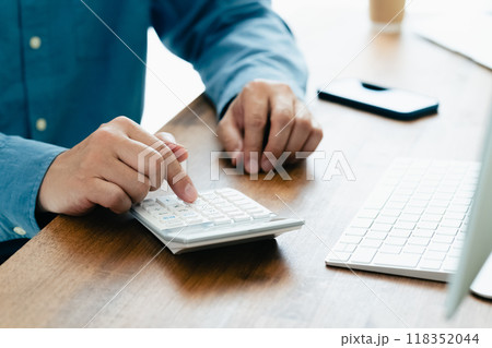 電卓で計算する男性の手元 電卓で計算する男性の手元 118352044