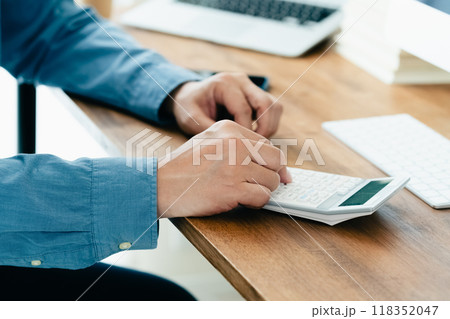 電卓で計算する男性の手元 118352047