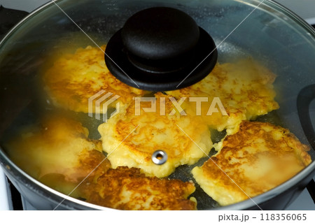 Potatoes pancakes, draniki cooking in frying pan on gas oven on kitchen. Potatoes pancakes, draniki cooking in frying pan on gas oven on kitchen. 118356065