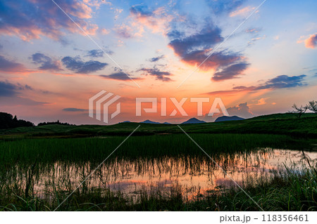 2024年すすきの穂が出始めたばかりの曽爾高原の夕景　鮮やかな朱色に染まる山際の夕焼けと大空の茜雲① 118356461
