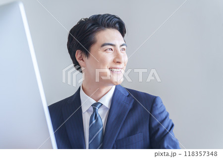 デスクトップパソコンで仕事をするビジネスマン 118357348