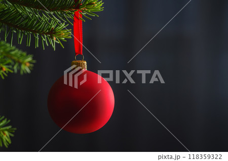 Red christmas ball hanging on spruce tree indoor with copy space Red christmas ball hanging on spruce tree indoor with copy space 118359322